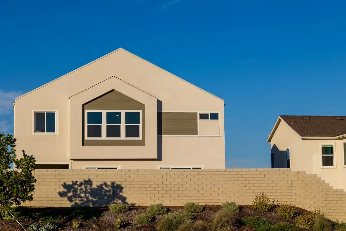 After: Front facade — dated siding removed, stone veneer installed over proper drainage mat