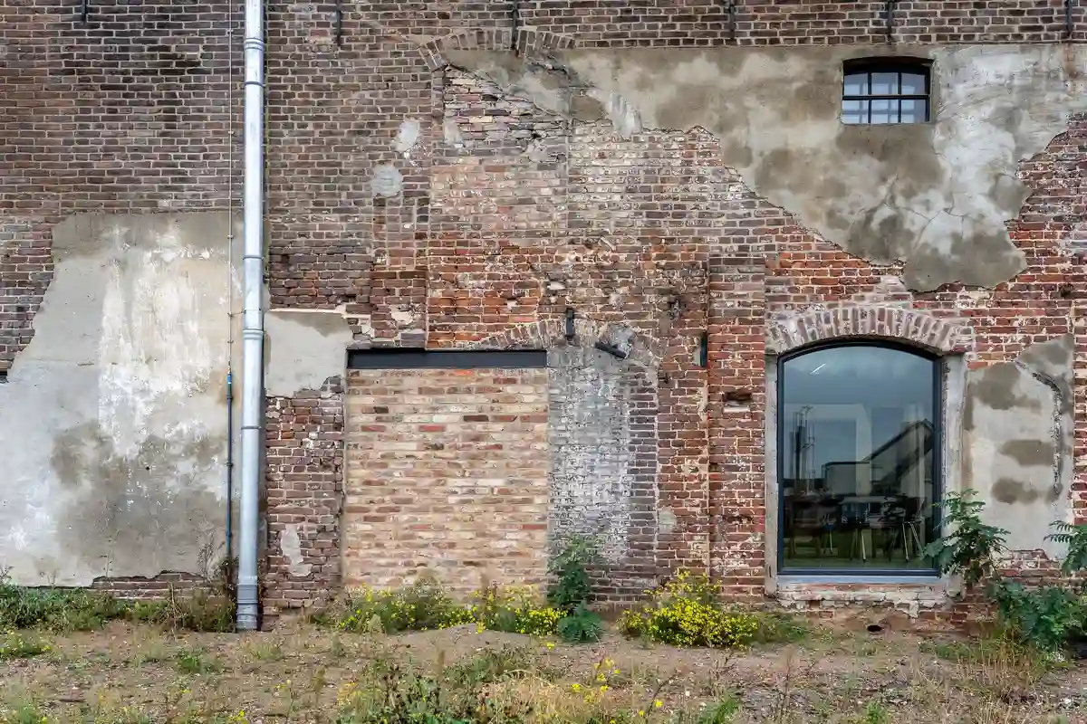 Before: Main facade — original failing commercial brick restored and matched across full elevation
