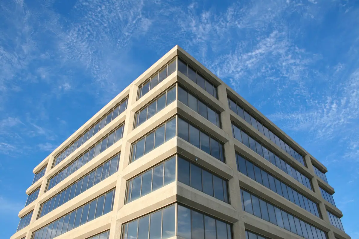 After: Primary facade — plain concrete wall clad with anchored natural stone veneer panels