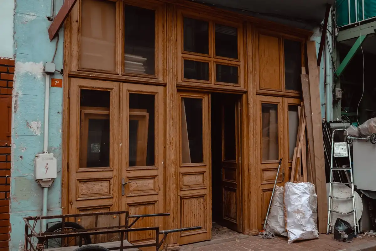 Before: Primary facade — plain concrete wall clad with anchored natural stone veneer panels