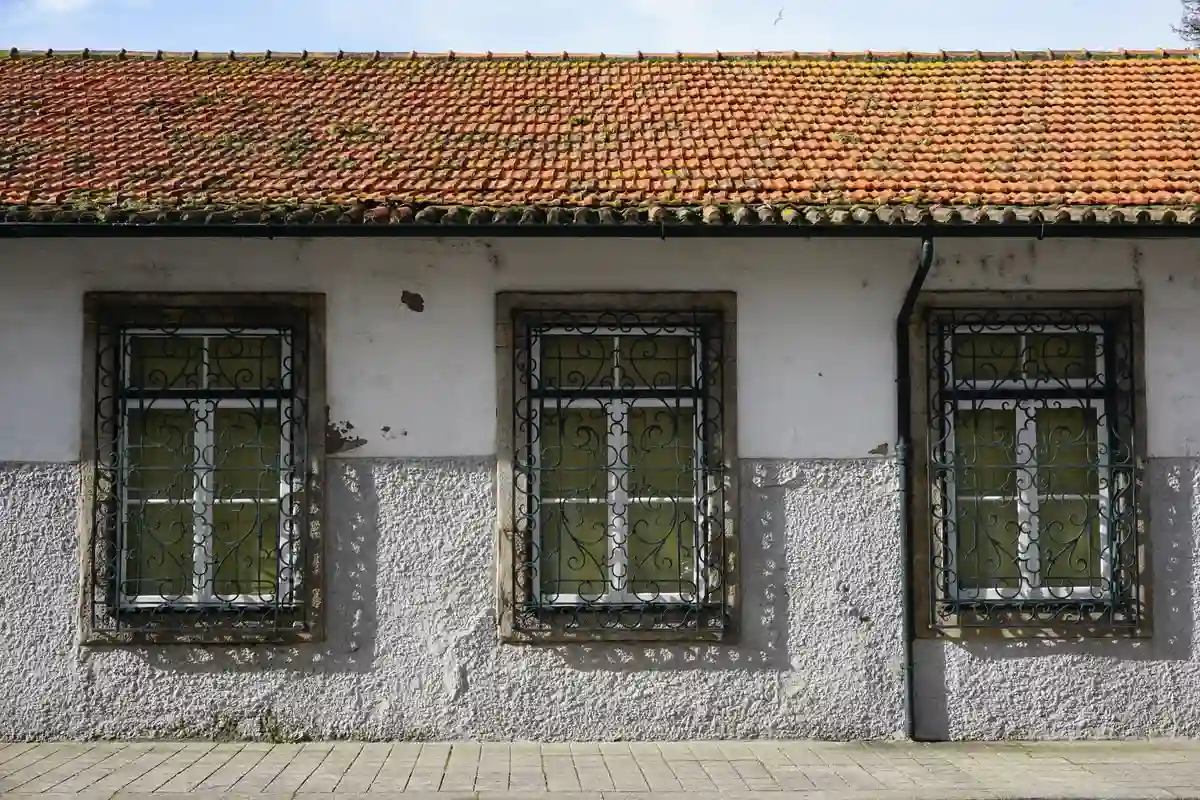 Before: Side elevation — stone veneer cladding with soldier course cap detail at window sills